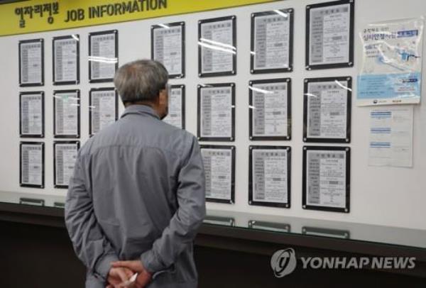 A man checks lists of job openings at a welfare center in Seoul in this file photo taken April 17, 2023. (Yonhap)