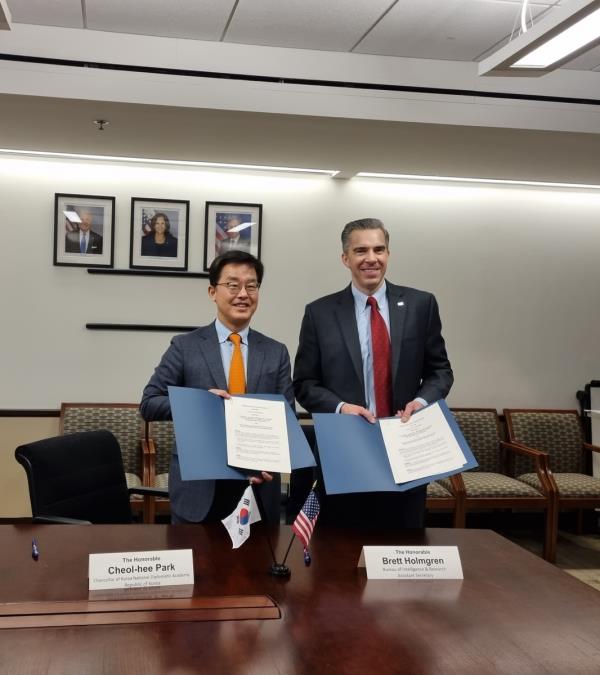 Park Cheol-hee (L), chancellor of the Korea Natio<em></em>nal Diplomatic Academy, and Brett Holmgren, U.S. assistant secretary of state for intelligence and research, pose for a photo after signing an arrangement on bilateral cooperation in Washington on Dec. 6, 2023 in this photo released by the academy. (PHOTO NOT FOR SALE) (Yonhap)