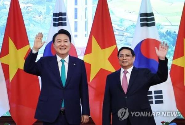 South Korean President Yoon Suk Yeol (L) and Vietnamese Prime Minister Pham Minh Chinh wave during their meeting in Hanoi, in this June 23, 2023, file photo. (Yonhap)