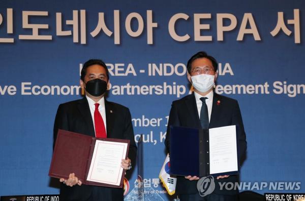 In this file photo taken on Dec. 18, 2020, then Industry Minister Sung Yun-mo (R) poses for a photo with his Indo<em></em>nesian counterpart, Agus Suparmanto, during a ceremony at a Seoul hotel to sign the comprehensive eco<em></em>nomic partnership agreement between the two countries. (Yonhap)