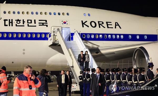 South Korean President Yoon Suk Yeol and his wife, Kim Keon Hee, (on stairs) arrive at Amsterdam Airport Schiphol for a four-day state visit on Dec. 11, 2023. (Pool photo) (Yonhap)