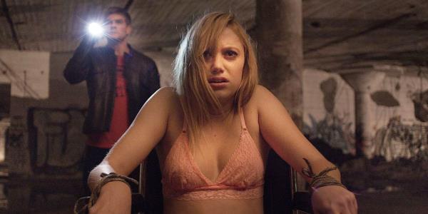 Maika Mo<em></em>nroe as Jay strapped to a chair in her undergarments in It Follows.